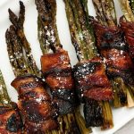 bacon wrapped maple parmesan asparagus bundles in a rectangular plate