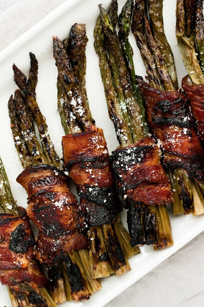 bacon wrapped maple parmesan asparagus bundles in a rectangular plate