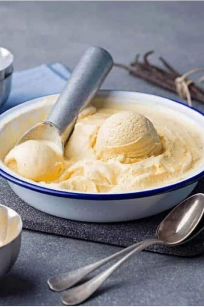 keto ice cream being scooped in an ice cream bowl atop a marble table