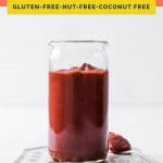 coral colored Pinterest pin image of a glass of keto ketchup