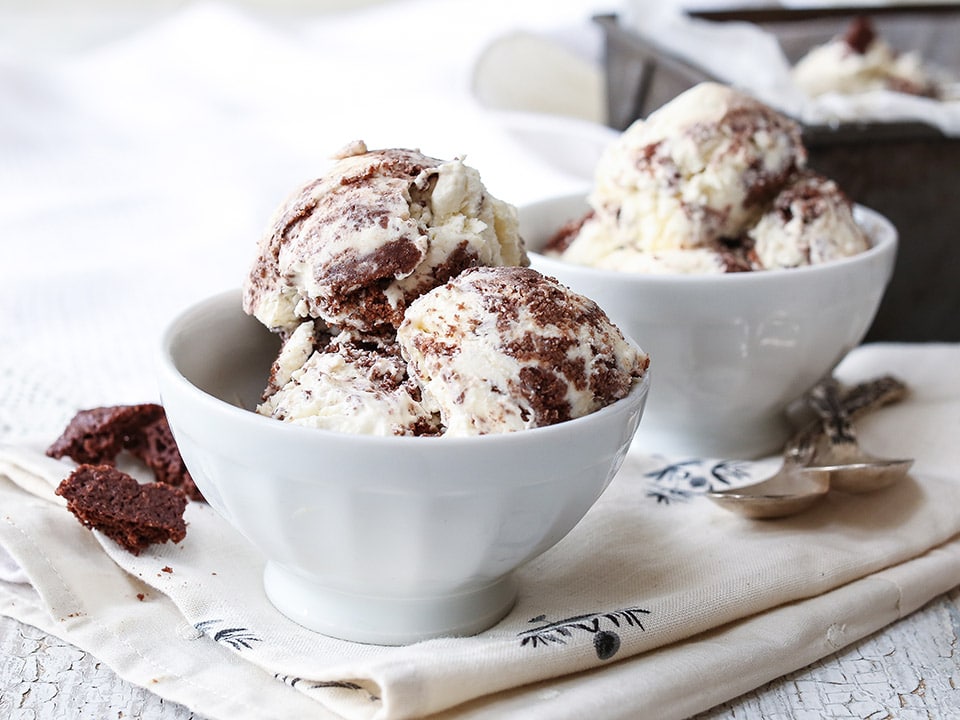 angled shot of 2 bowls of sugar-free keto cookies and cream ice cream atop a marble kitchen counter