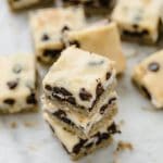 close-up angled image of keto magic bars stacked on top of each other atop a marble kitchen counter