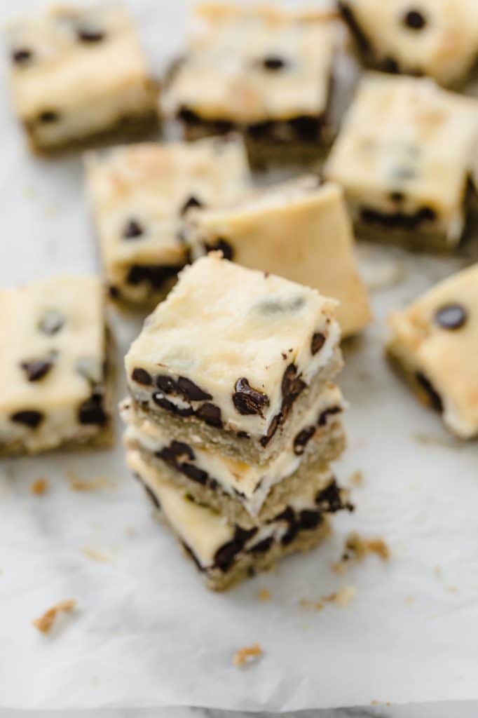 close-up angled image of keto magic bars stacked on top of each other atop a marble kitchen counter