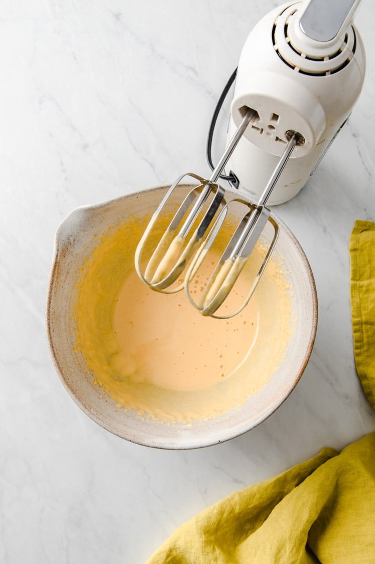 mixed egg yolk and monk fruit sweetener in a mixing bowl with an electric mixer