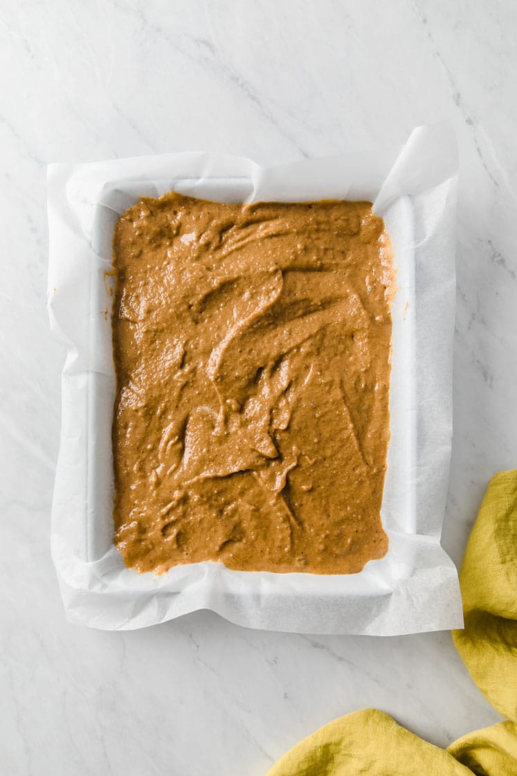 baking pan lined with parchment paper filled with batter