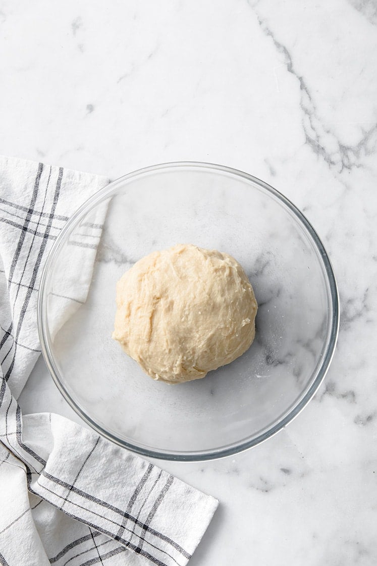 keto garlic dough ball fathead dough in a mixing bowl atop a marble kitchen counter