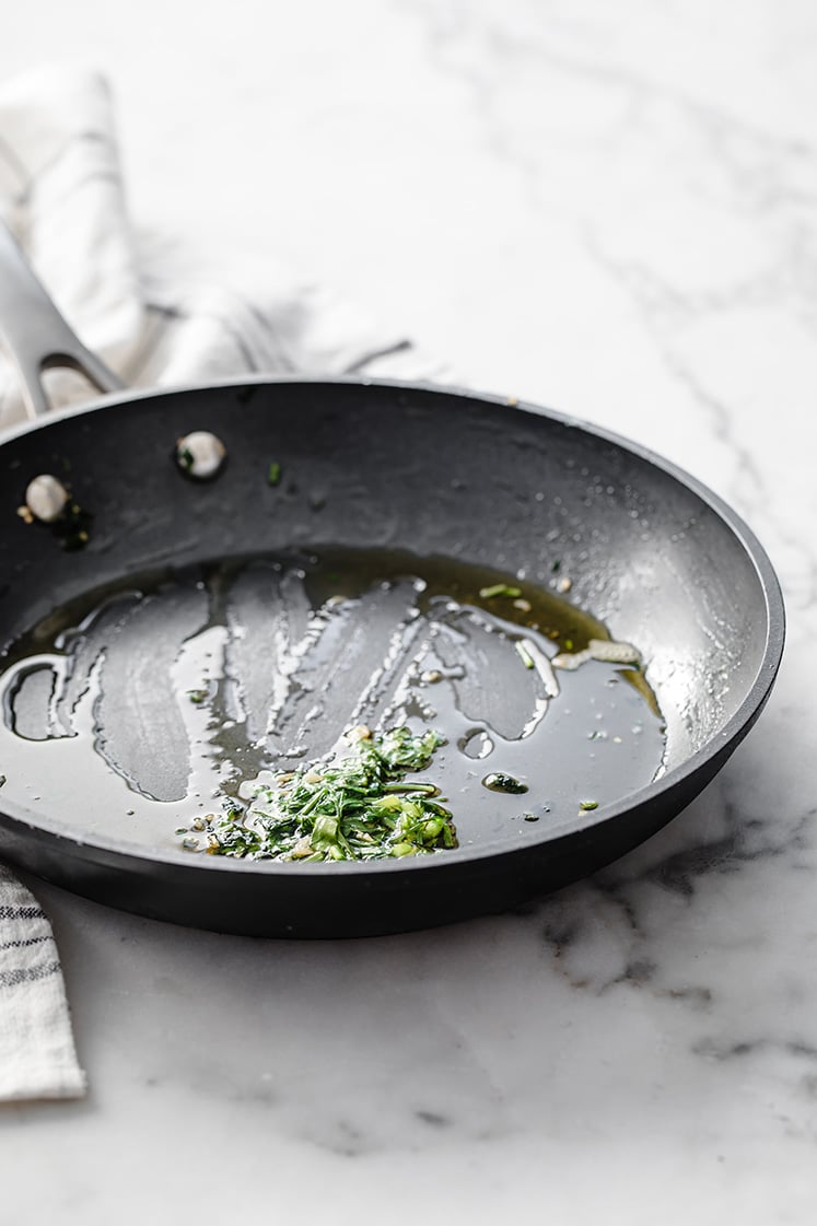 melted garlic butter in a pan atop a marble kitchen table