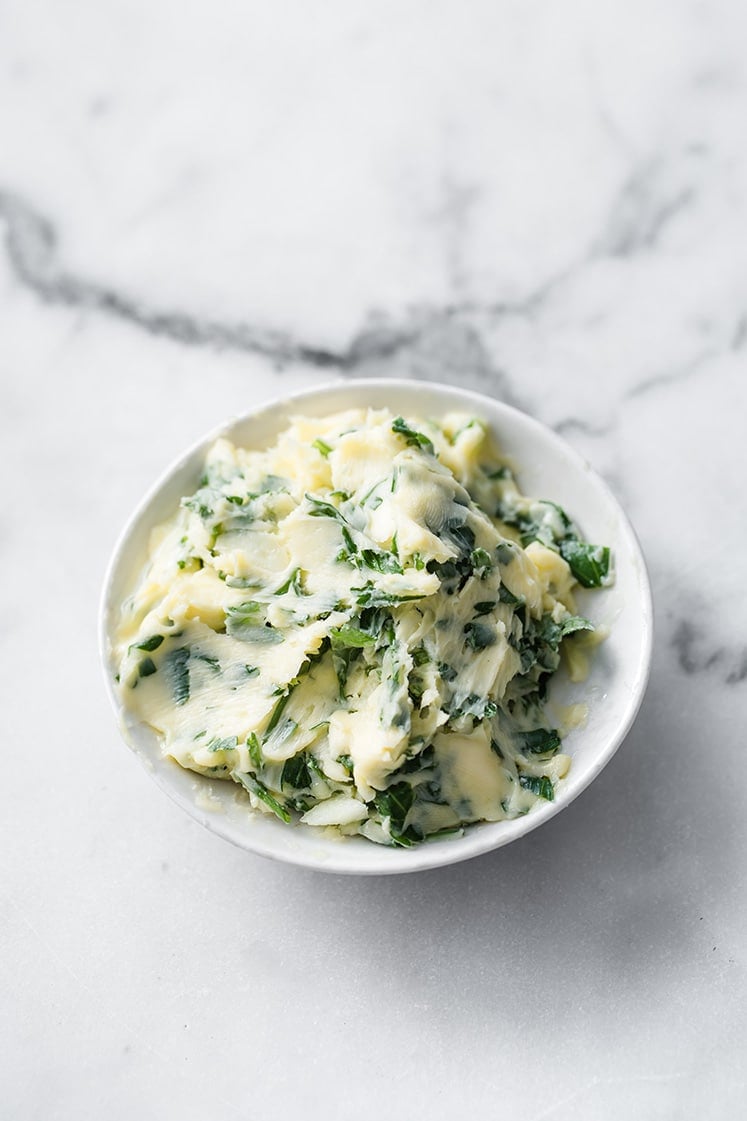 garlic butter in a saucer atop a marble kitchen counter
