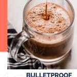 Pinterest pin image of bulletproof peppermint mocha drink being poured into glass coffee mug with recipe title text below the image and colored decorative lines on the side and bottom
