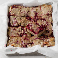 featured image of keto raspberry crumble bars straight out of the oven atop a marble kitchen counter