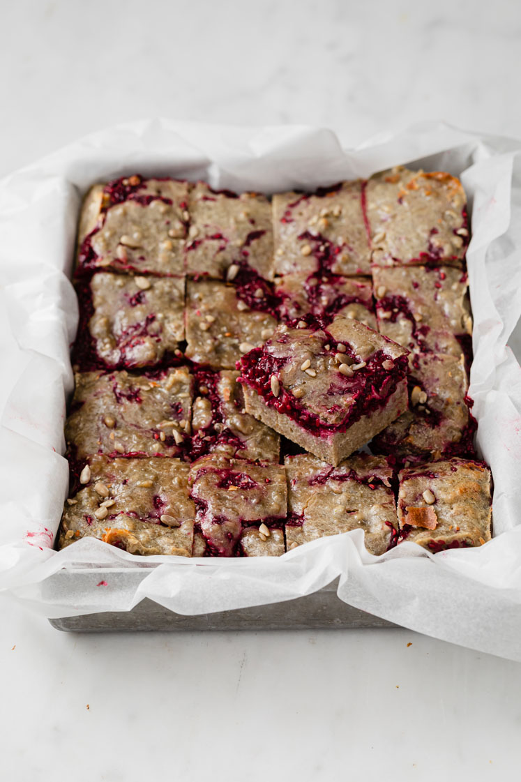 featured image of keto raspberry crumble bars straight out of the oven atop a marble kitchen counter