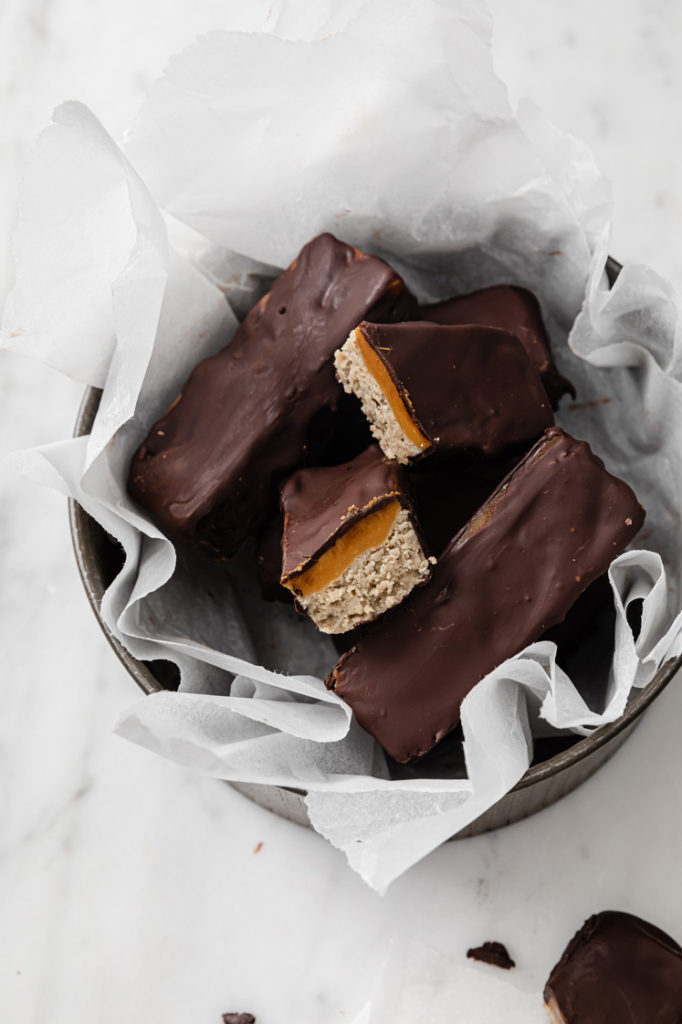 angled overhead image of a baking pan filled with nut-free keto twix bars atop a marble kitchen counter