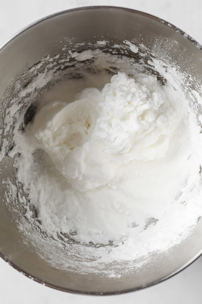 dry ingredients mixed with stiff egg whites in a mixing bowl