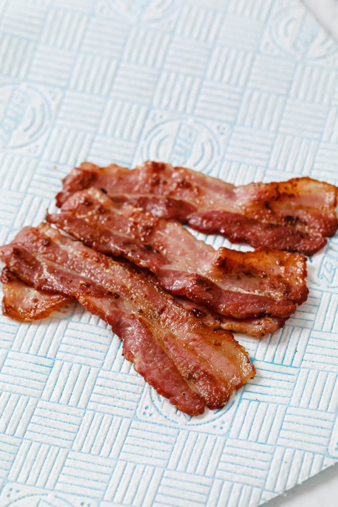 cooked bacon de-greasing atop paper towel