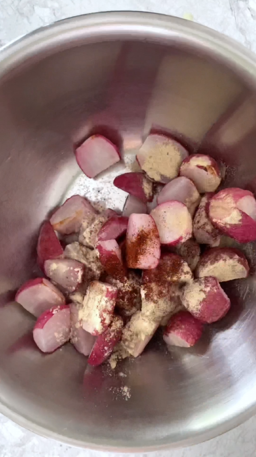 partially cooked radishes with spices in stainless steel bowl