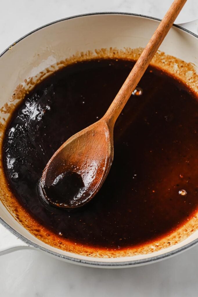 Overhead shot of the sauce, mixed in a ceramic bowl with a wooden spoon. The ceramic bowl is resting on a marble countertop.