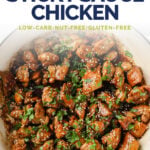 Low-Carb Sticky Sauce Chicken Pinterest graphic. Photo below shows an overhead shot of a large pan with the sweet sticky chicken thighs, garnished with freshly-cracked pepper, sesame seeds, and fresh parsley.