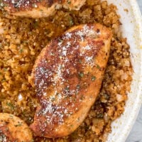 overhead shot of cooked chicken breast in pan atop cauliflower rice