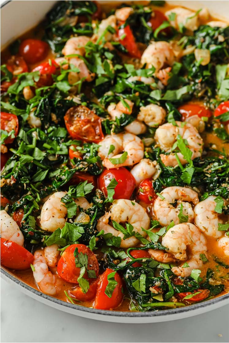 Side, close-up shot of the One-Pan Low-Carb Tuscan Garlic Shrimp, garnished with chopped fresh parsley and Italian seasoning, served in a cooking pot.