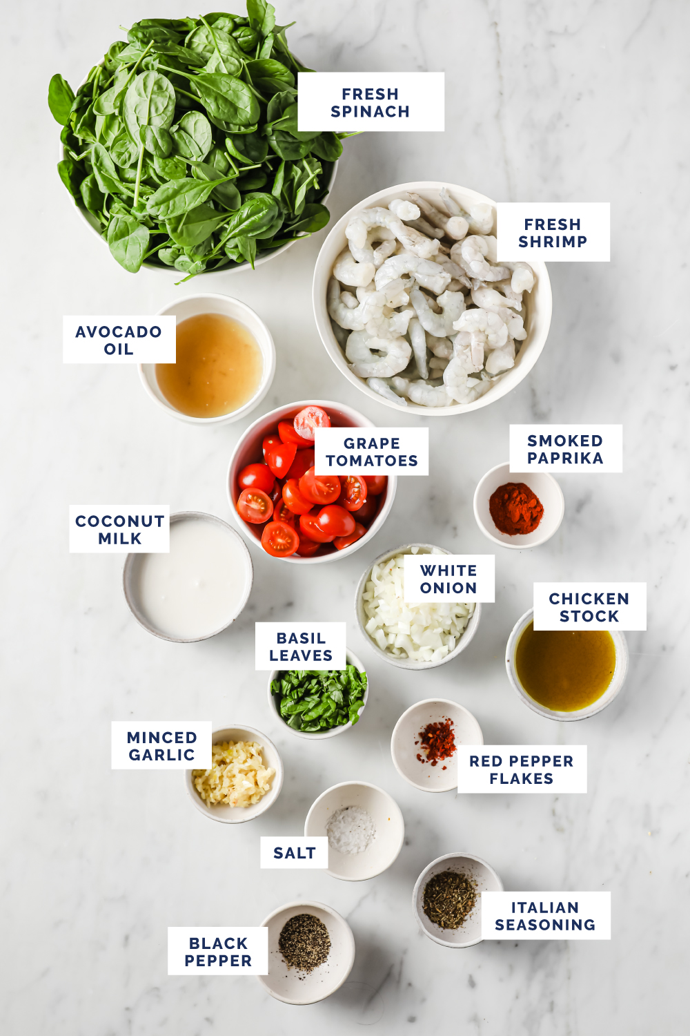 Overhead shot of labeled ingredients for the One-Pan Low-Carb Tuscan Garlic Shrimp on a marble countertop.