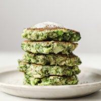 Stacked broccoli fritters on a plate.