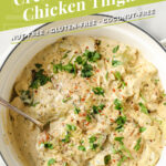 Creamy Artichoke Chicken Thighs Graphic Pin. Photo shows an overhead shot of a large pan with Creamy Artichoke Chicken Thighs, garnished with fresh parsley, freshly cracked pepper, and red pepper flakes. You can also see a serving spoon scooping up a portion of the dish in the pan.