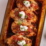 overhead shot of garnished chicken bake casserole dish sitting diagonally atop marble countertop