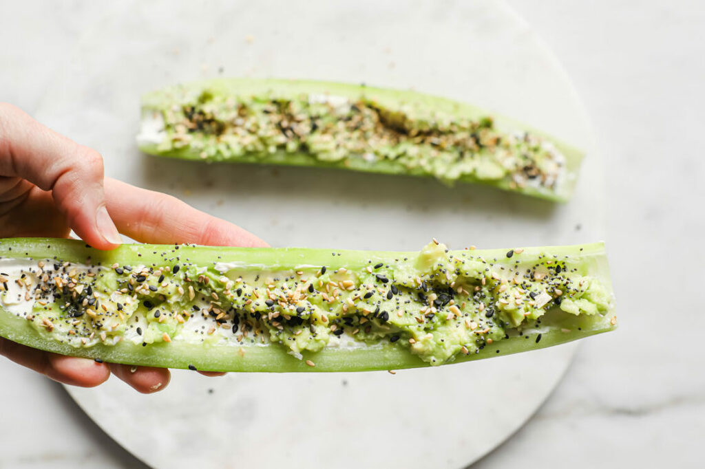 Overhead close-up shot of Everything Bagel Seasoning Cucumber Boats atop a marble plate. The plate rests atop a marble countertop.