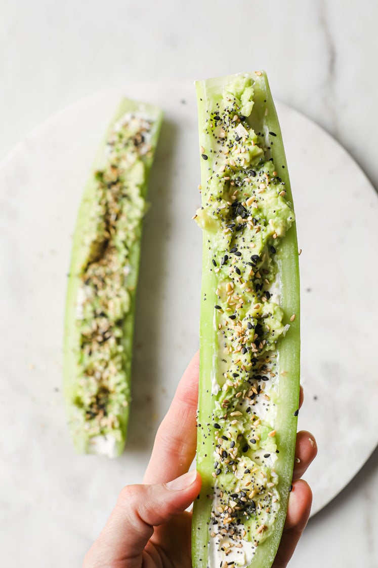 Overhead close-up shot of Everything Bagel Seasoning Cucumber Boats atop a marble plate. The plate rests atop a marble countertop.