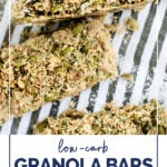 Low Carb Granola Bars WordPress Pin. The photo shows an overhead close-up shot of Low Carb Granola Bars sprinkled with shredded coconut over a striped cloth table kitchen napkin. Below the photo, there’s text in navy blue letters that say “Low-Carb Granola Bars” and an avocado green text box with white letters that say “paleo · nut-free · dairy-free”. Below, there’s text in navy blue letters that say ”realbalanced.com”.