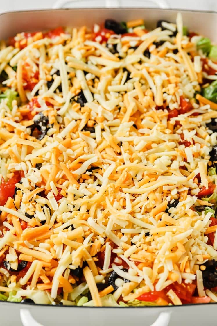 Prepared Taco Dip With Cream Cheese in a baking dish atop a marble counter.