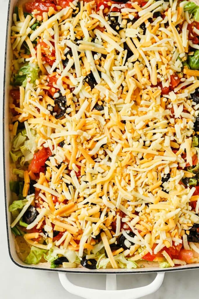 Taco Dip With Cream Cheese in a baking dish atop a marble counter.