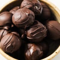 Chocolate Peanut Butter Balls in a bowl atop a marble counter.