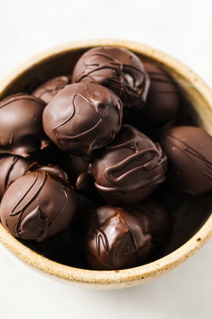 Chocolate Peanut Butter Balls in a bowl atop a marble counter.
