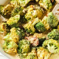 Creamy Italian Broccoli With Sun-Dried Tomatoes garnished with black pepper in a large pan.