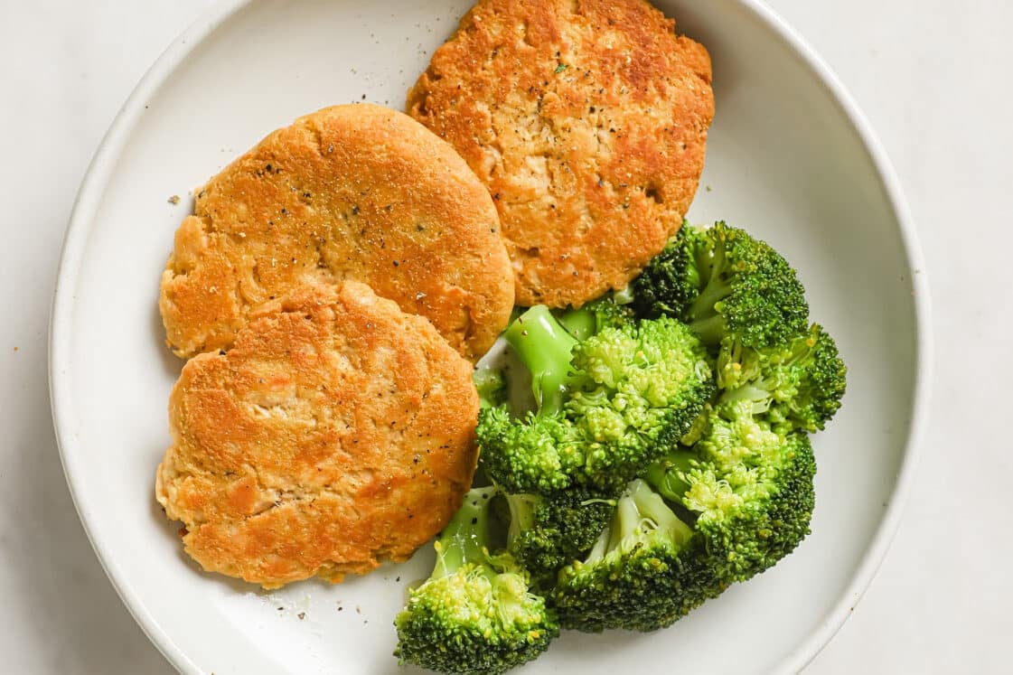 Chicken patties with broccoli on a plate.