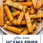 Golden Jicama Fries WordPress Pin. The photo shows the Golden Jicama Fries garnished with freshly chopped parsley on a parchment paper-lined plate atop a marble counter.. Below the photo, there’s text that reads: Golden Jicama Fries. There’s also an avocado-green box with text that reads: “low-carb side dish”. At the bottom, there’s text that reads: “realbalanced.com”.