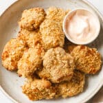 Keto Chicken Nuggets on a ceramic bowl with a small bowl of dip atop a marble counter.