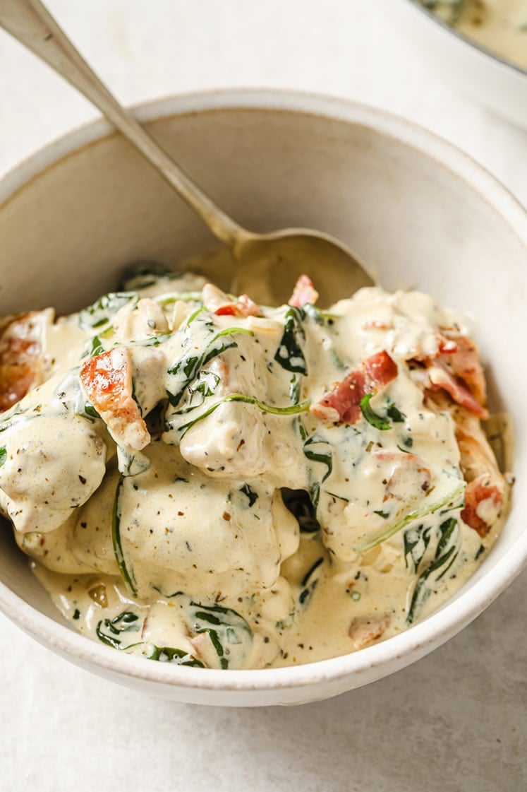 A bowl of creamy dijon chicken with a spoon.