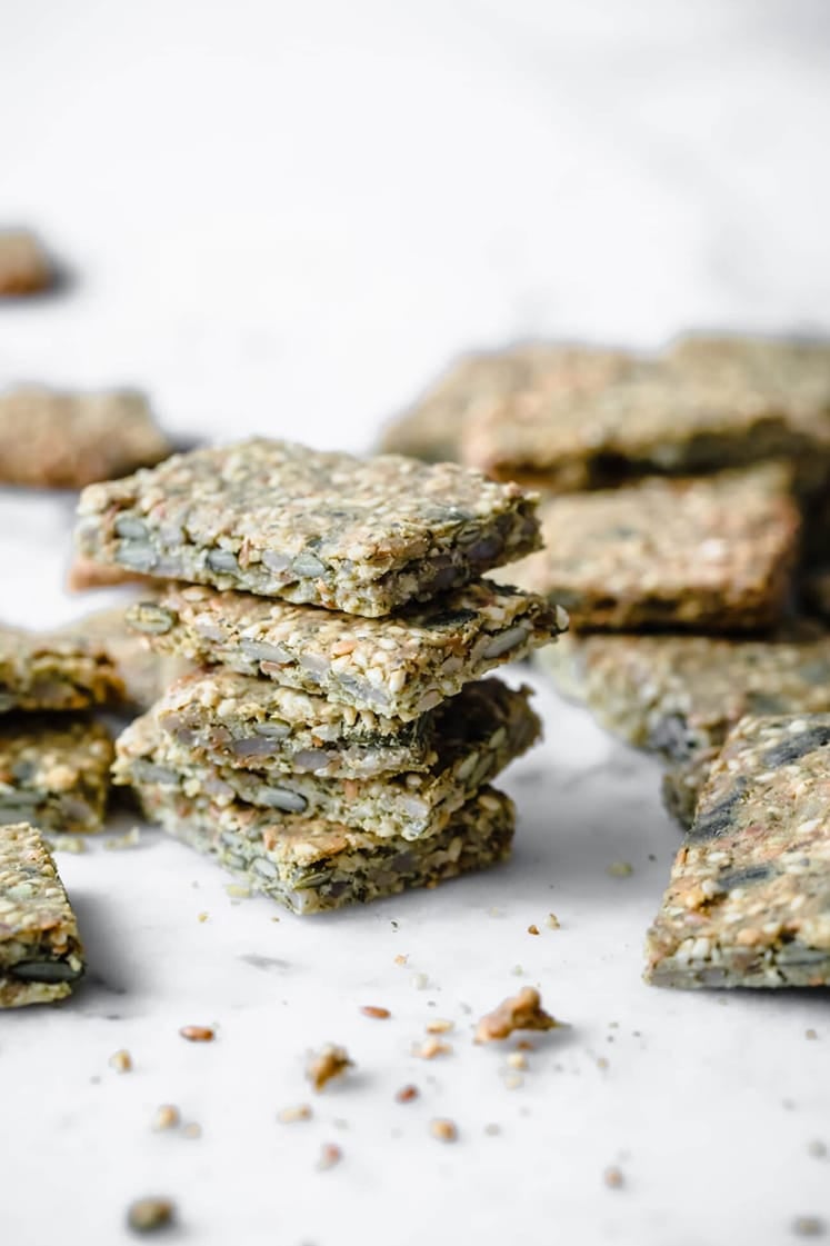 Seed crackers stacked atop a marble counter.