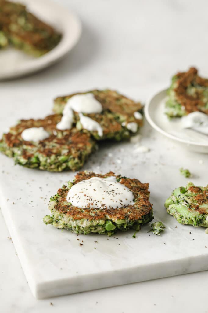 Close-up of broccoli fritters topped with Greek yogurt dip.