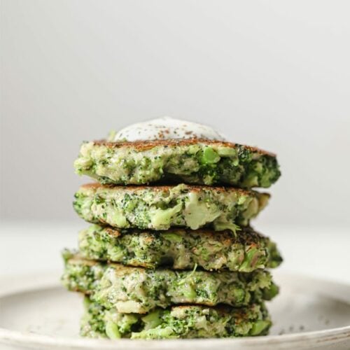 Stacked broccoli fritters on a plate.