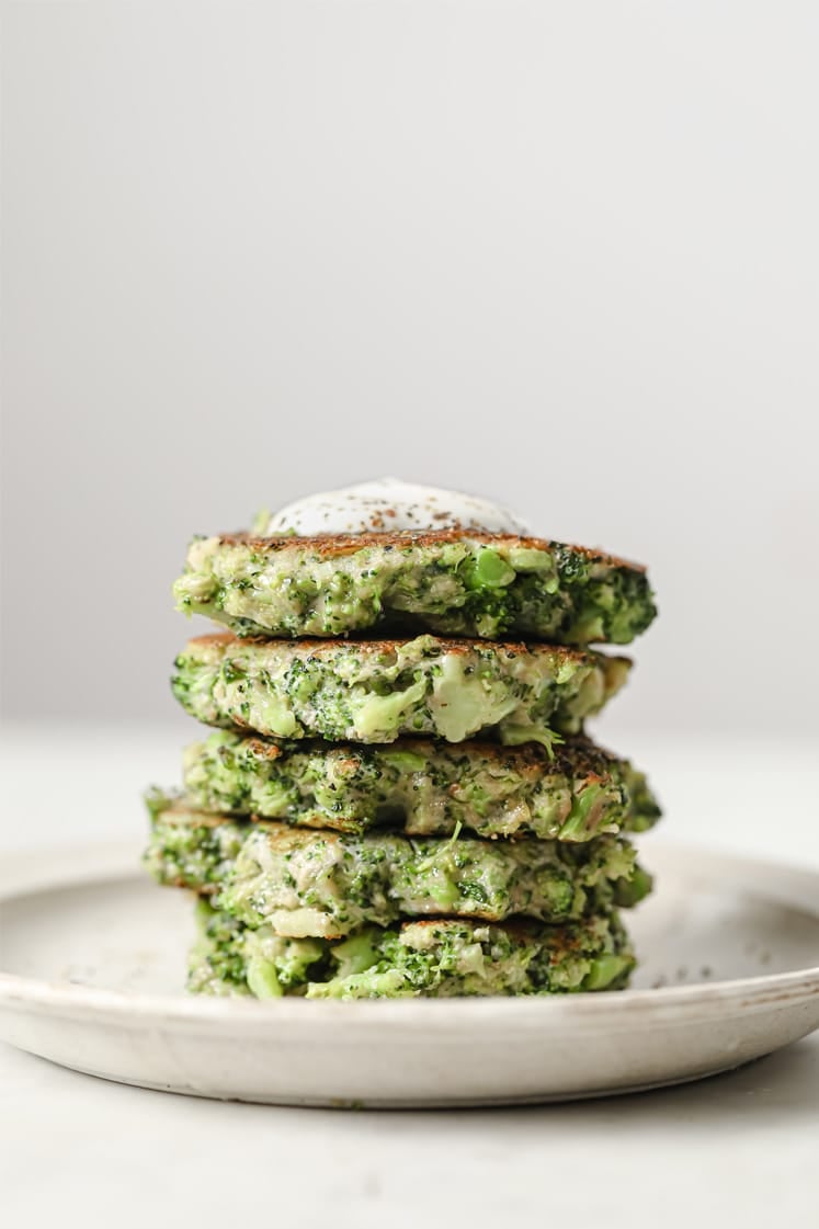 Stacked broccoli fritters on a plate.