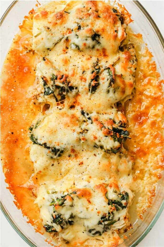 Creamy spinach chicken bake on a glass baking dish.