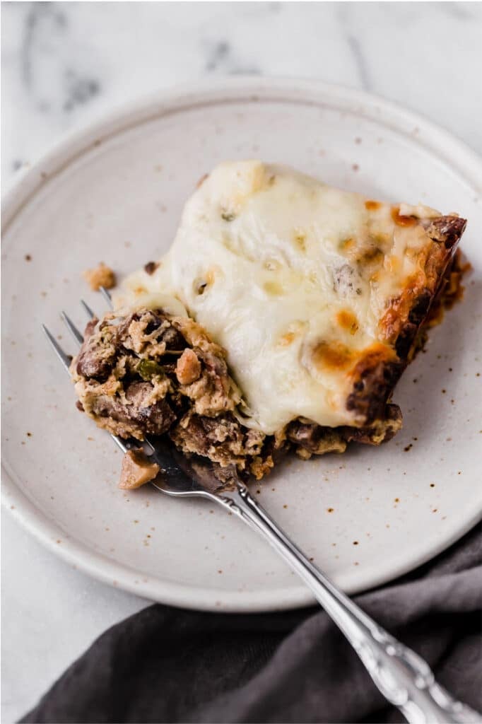 A serving of Philly cheese steak casserole on a plate with a fork.
