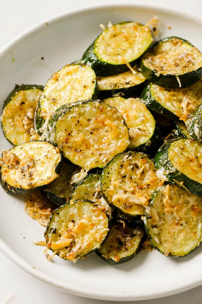 Baked zucchini slices on a white plate.