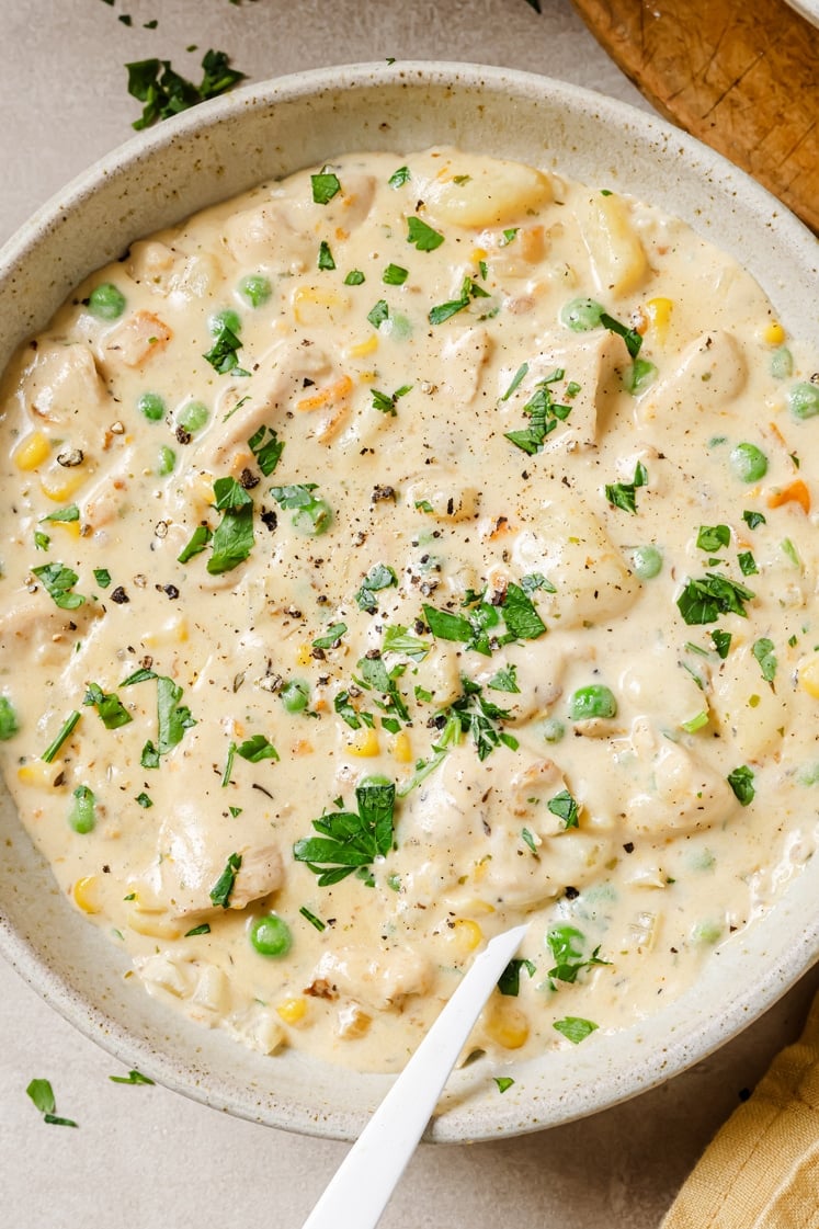 A bowl chicken pot pie soup with a spoon.