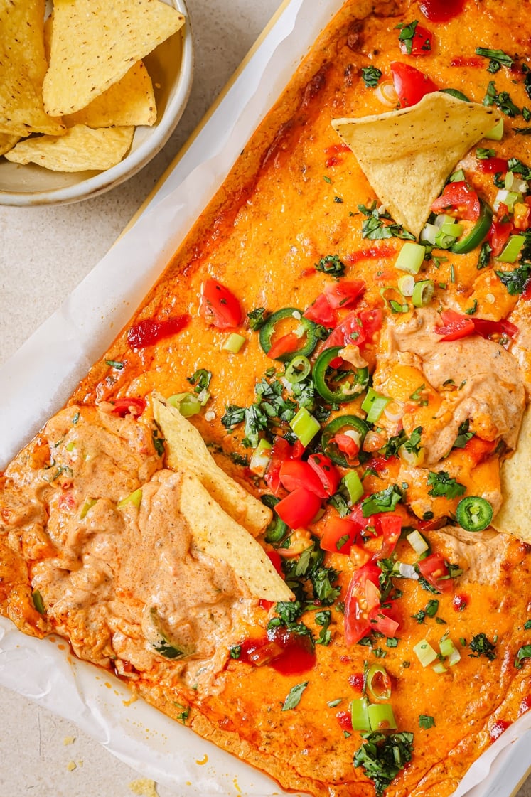 Chili cheese dip in a baking dish with tortilla chips.