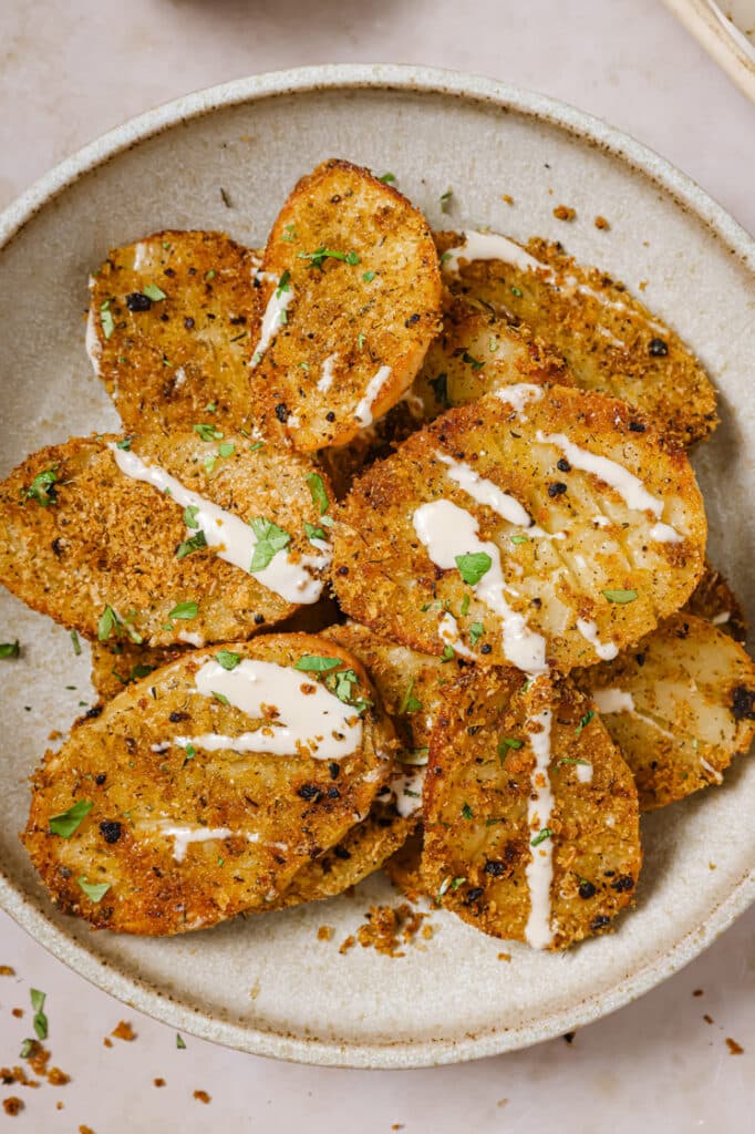 A plate of garnished parmesan crusted potatoes.