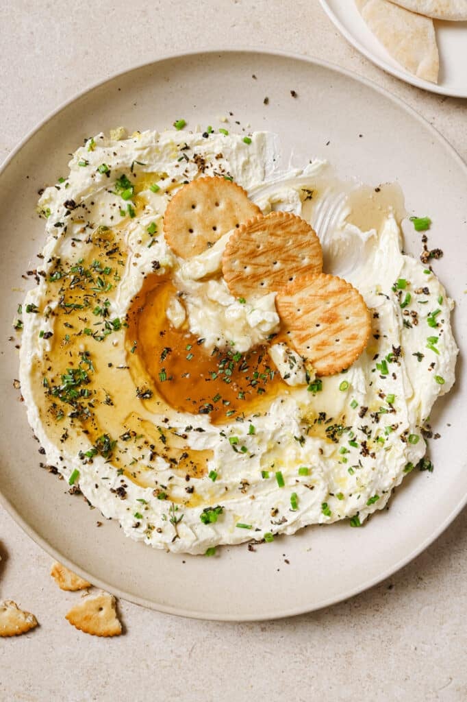 Whipped feta with honey and crackers on a plate.